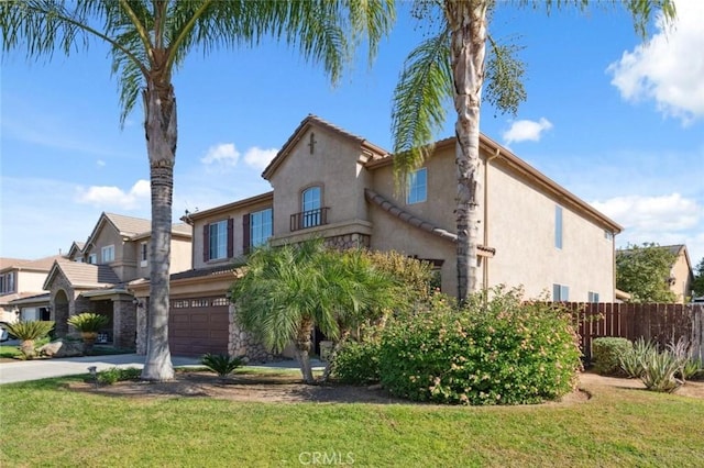 7538 N Erie Ave, Fresno, CA 93722 - mediterranean / spanish home featuring an attached garage, stucco siding, and concrete driveway