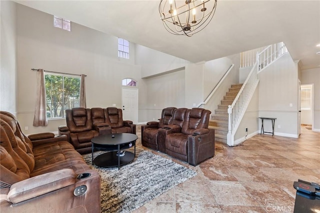 7538 N Erie Ave, Fresno, CA 93722 - living area with stairway, a chandelier, stone finish flooring, and a towering ceiling