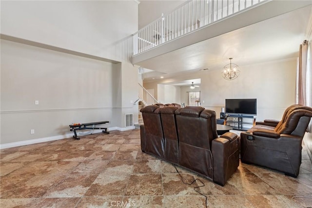 7538 N Erie Ave, Fresno, CA 93722 - living room with stairway, a chandelier, a high ceiling, stone finish floors, and ceiling fan