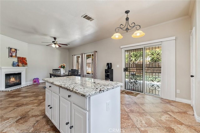 7538 N Erie Ave, Fresno, CA 93722 - kitchen with hanging light fixtures, a center island, ceiling fan, white cabinetry, and crown molding
