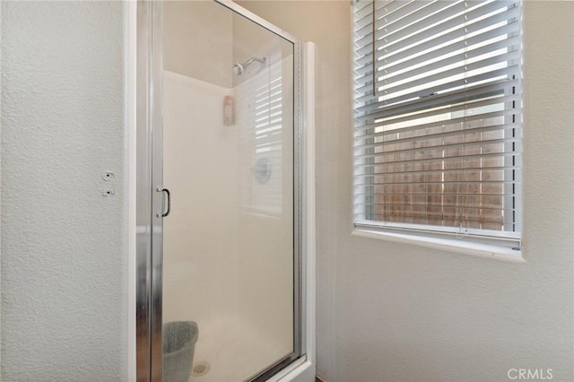 7538 N Erie Ave, Fresno, CA 93722 - bathroom featuring a stall shower, healthy amount of natural light, and a textured wall