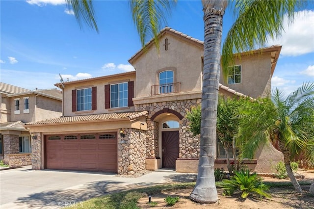 7538 N Erie Ave, Fresno, CA 93722 - mediterranean / spanish home with stucco siding, stone siding, concrete driveway, an attached garage, and a tile roof