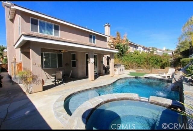 29429 Masters Dr, Murrieta, CA 92563 - rear view of property with a pool with connected hot tub, stucco siding, a patio, and a ceiling fan
