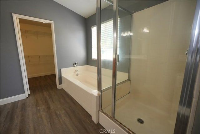 29429 Masters Dr, Murrieta, CA 92563 - bathroom with wood finished floors, a stall shower, a garden tub, a walk in closet, and baseboards