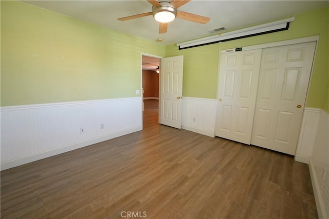 29429 Masters Dr, Murrieta, CA 92563 - unfurnished bedroom with a wainscoted wall, wood finished floors, a closet, and ceiling fan