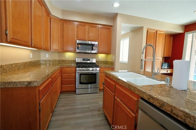 29429 Masters Dr, Murrieta, CA 92563 - kitchen with appliances with stainless steel finishes, a sink, recessed lighting, light wood finished floors, and brown cabinetry