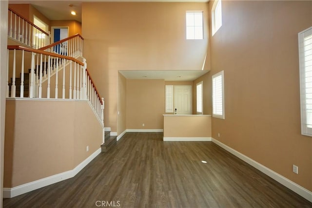 29429 Masters Dr, Murrieta, CA 92563 - unfurnished living room with stairs, wood finished floors, a towering ceiling, and baseboards