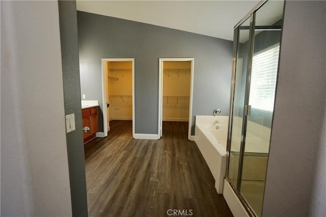 29429 Masters Dr, Murrieta, CA 92563 - full bathroom with wood finished floors, a garden tub, a shower stall, vanity, and lofted ceiling