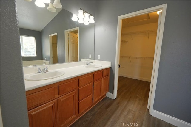 29429 Masters Dr, Murrieta, CA 92563 - full bathroom with wood finished floors, double vanity, vaulted ceiling, baseboards, and a walk in closet