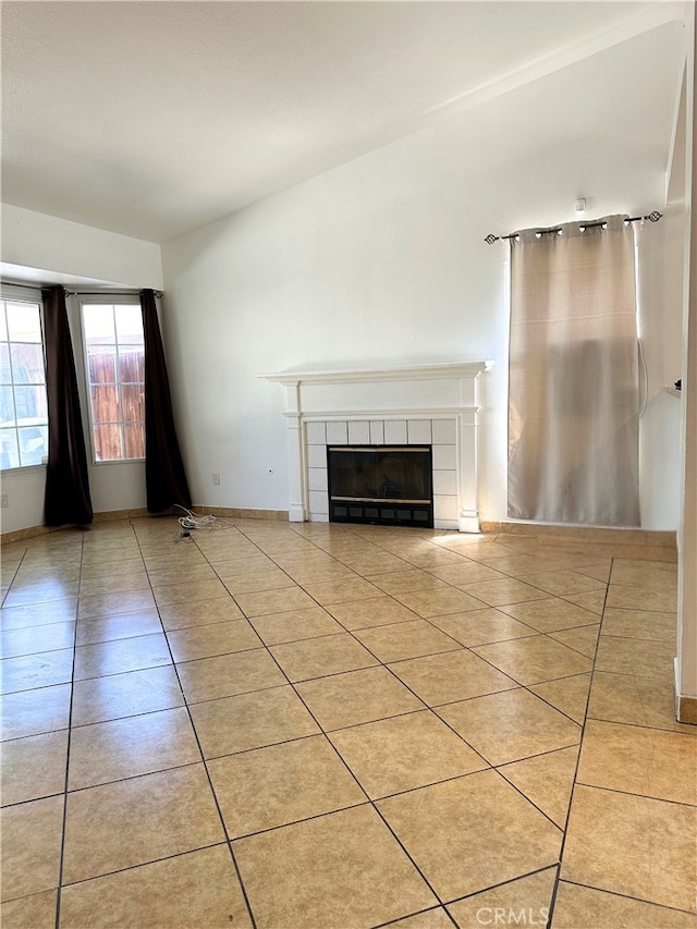 2582 Buchanan Ct, Perris, CA 92571 - unfurnished living room featuring a tiled fireplace, light tile patterned floors, and baseboards