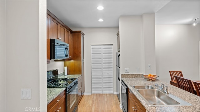 2123 Scholarship, Irvine, CA 92612 - kitchen with black appliances, a sink, light wood-style floors, brown cabinets, and recessed lighting