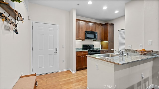 2123 Scholarship, Irvine, CA 92612 - kitchen with black appliances, a sink, light wood-type flooring, a peninsula, and recessed lighting