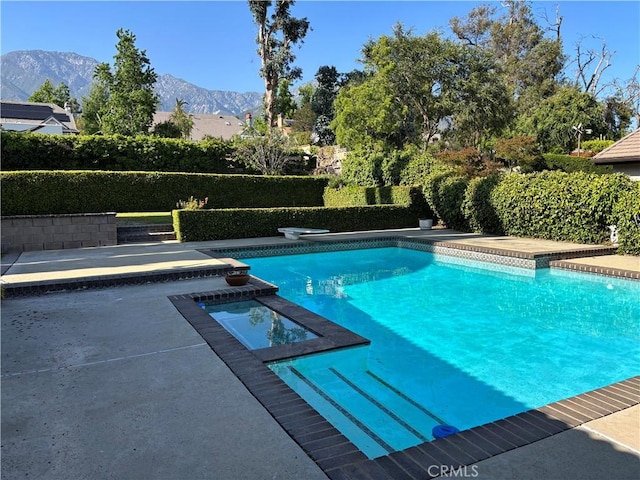 7950 Gardenia, Rancho Cucamonga, CA 91701 - view of pool with a mountain view, a pool with connected hot tub, a diving board, and a patio area