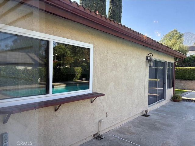 7950 Gardenia, Rancho Cucamonga, CA 91701 - view of side of property with stucco siding, a patio area, and a tiled roof