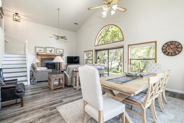 12355 Santa Ana Rd, Atascadero, CA 93422 - dining room featuring ceiling fan, high vaulted ceiling, wood finished floors, stairs, and a brick fireplace