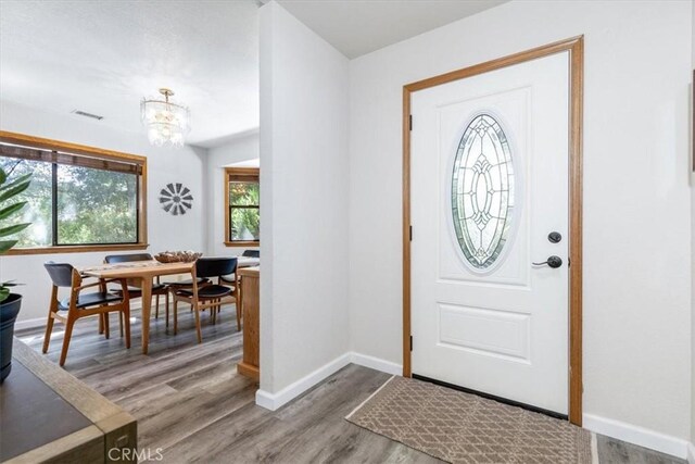 12355 Santa Ana Rd, Atascadero, CA 93422 - foyer featuring a chandelier, wood finished floors, and baseboards