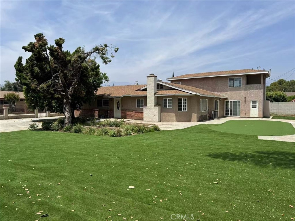 11849 Lower Azusa Rd, El Monte, CA 91732 - back of property featuring an area to practice putting, a chimney, and stucco siding