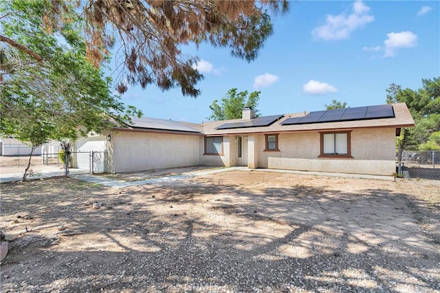 19002 Vine St, Hesperia, CA 92345 - ranch-style house with a gate, stucco siding, roof mounted solar panels, and a chimney
