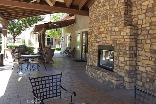 211 Furyk Way, Hemet, CA 92545 - view of patio / terrace featuring an outdoor stone fireplace, a ceiling fan, outdoor dining space, and a gazebo