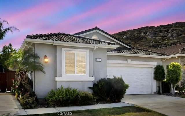 211 Furyk Way, Hemet, CA 92545 - view of front facade with stucco siding, an attached garage, concrete driveway, a tile roof, and a mountain view