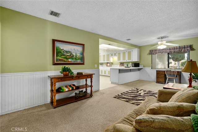 2380 Peppertree Ln, Riverside, CA 92506 - living area featuring a wainscoted wall, a textured ceiling, light colored carpet, and a ceiling fan