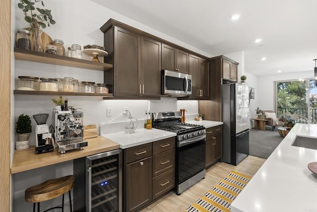 1836 Mesquite, Oceanside, CA 92056 - kitchen featuring appliances with stainless steel finishes, dark brown cabinets, light countertops, wine cooler, and light wood finished floors