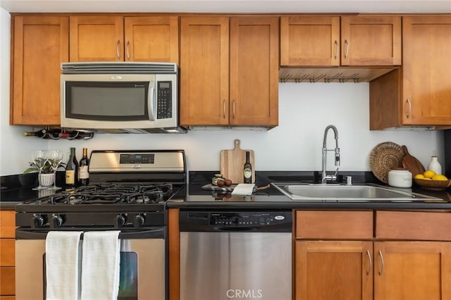 420 S San Pedro St Unit 211, Los Angeles, CA 90013 - kitchen with appliances with stainless steel finishes, a sink, dark countertops, and brown cabinetry