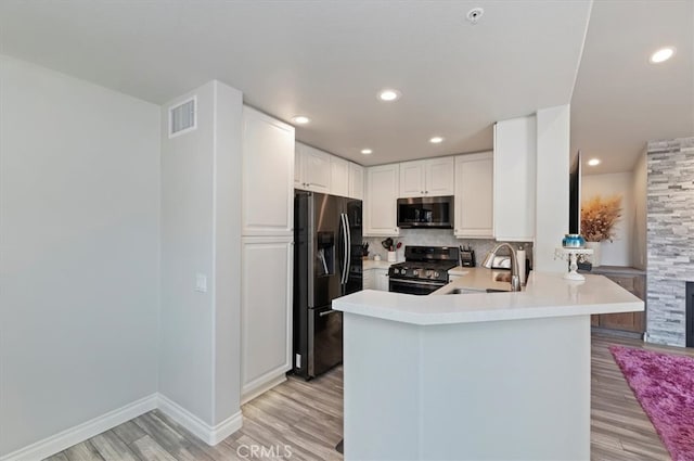1 Sorrento Ct, Newport Coast, CA 92657 - kitchen with stainless steel appliances, a sink, light wood-type flooring, a peninsula, and light countertops