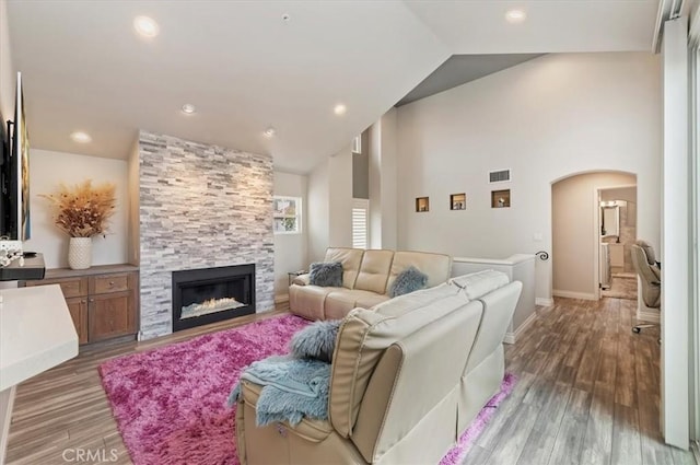 1 Sorrento Ct, Newport Coast, CA 92657 - living area featuring arched walkways, a fireplace, wood finished floors, baseboards, and high vaulted ceiling