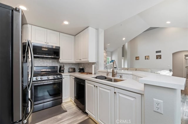 1 Sorrento Ct, Newport Coast, CA 92657 - kitchen featuring appliances with stainless steel finishes, white cabinetry, a peninsula, light wood-type flooring, and a sink
