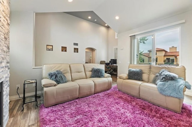 1 Sorrento Ct, Newport Coast, CA 92657 - living area with arched walkways, wood finished floors, a fireplace, high vaulted ceiling, and recessed lighting