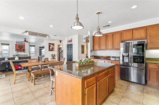 3568 Rock Butte Pl, Perris, CA 92570 - kitchen with stainless steel fridge, light tile patterned floors, brown cabinets, a center island, and recessed lighting