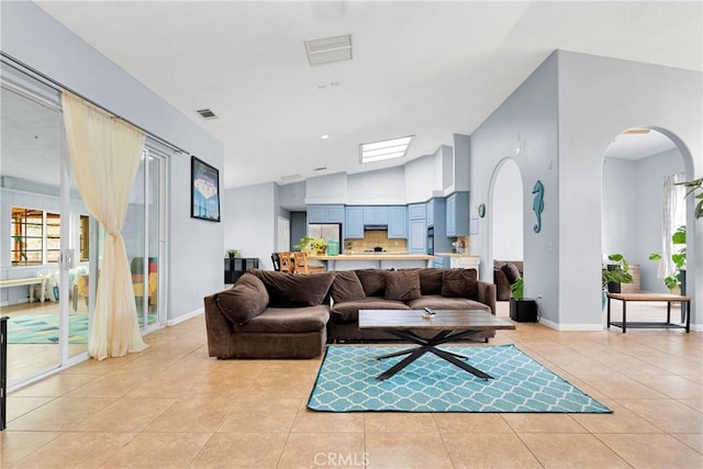 1679 Desert Front Rd, Wrightwood, CA 92397 - living area with light tile patterned flooring, arched walkways, lofted ceiling, and baseboards