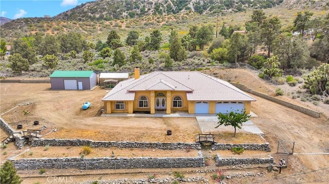 1679 Desert Front Rd, Wrightwood, CA 92397 - view of front of home with driveway, a tile roof, a chimney, a mountain view, and stucco siding