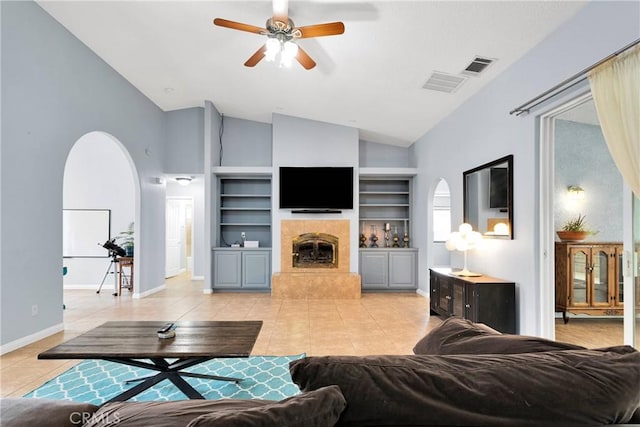 1679 Desert Front Rd, Wrightwood, CA 92397 - living room with light tile patterned floors, arched walkways, a ceiling fan, a fireplace, and built in shelves