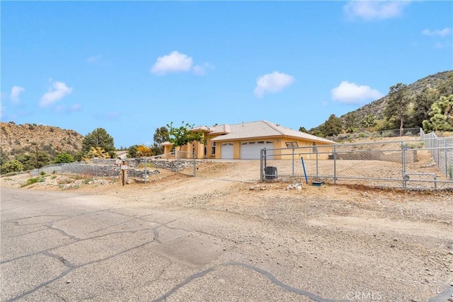 1679 Desert Front Rd, Wrightwood, CA 92397 - view of front of home featuring a garage, a gate, a mountain view, and driveway