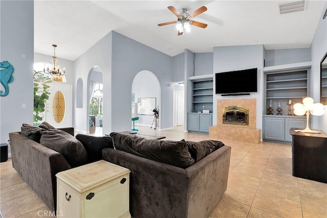 1679 Desert Front Rd, Wrightwood, CA 92397 - living area featuring arched walkways, ceiling fan, built in features, a tile fireplace, and light tile patterned floors