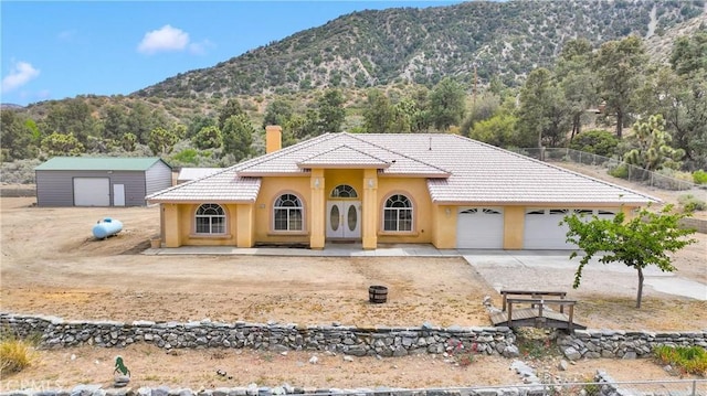 1679 Desert Front Rd, Wrightwood, CA 92397 - view of front of home featuring a mountain view, stucco siding, concrete driveway, a chimney, and a tile roof