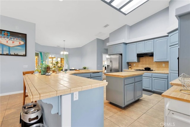 1679 Desert Front Rd, Wrightwood, CA 92397 - kitchen featuring stainless steel refrigerator with ice dispenser, a spacious island, light tile patterned floors, and decorative backsplash