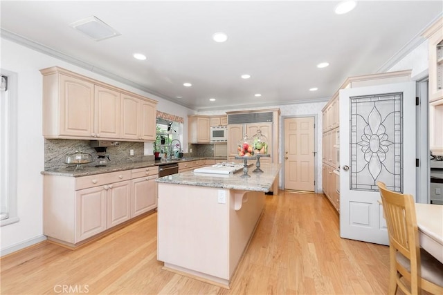 19043 Citronia St, Northridge, CA 91324 - kitchen featuring built in microwave, a kitchen island, crown molding, light wood-type flooring, and light stone countertops