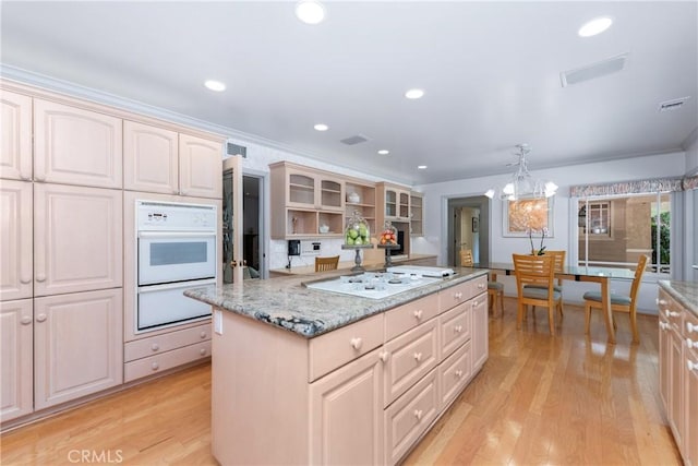 19043 Citronia St, Northridge, CA 91324 - kitchen with white stovetop, a kitchen island, light wood finished floors, light stone countertops, and glass insert cabinets