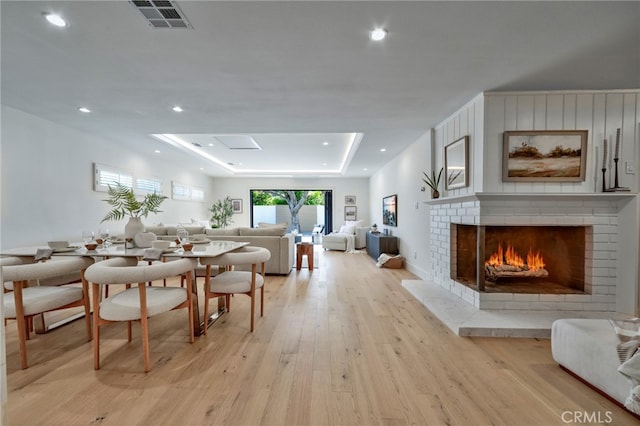 1035 Medford Rd, Pasadena, CA 91107 - dining space featuring a raised ceiling, light wood finished floors, a brick fireplace, and recessed lighting