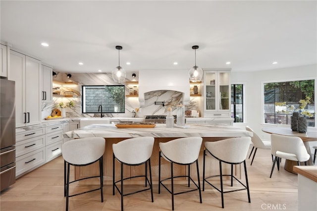 26065 Charing Cross Rd, Valencia, CA 91355 - kitchen with open shelves, freestanding refrigerator, a sink, decorative backsplash, and white cabinetry
