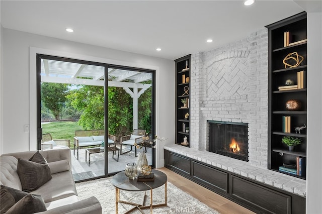 26065 Charing Cross Rd, Valencia, CA 91355 - living room with built in features, light wood-style floors, a fireplace, and recessed lighting