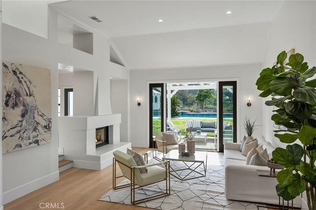 26065 Charing Cross Rd, Valencia, CA 91355 - living area featuring plenty of natural light, light wood-style floors, baseboards, a glass covered fireplace, and high vaulted ceiling