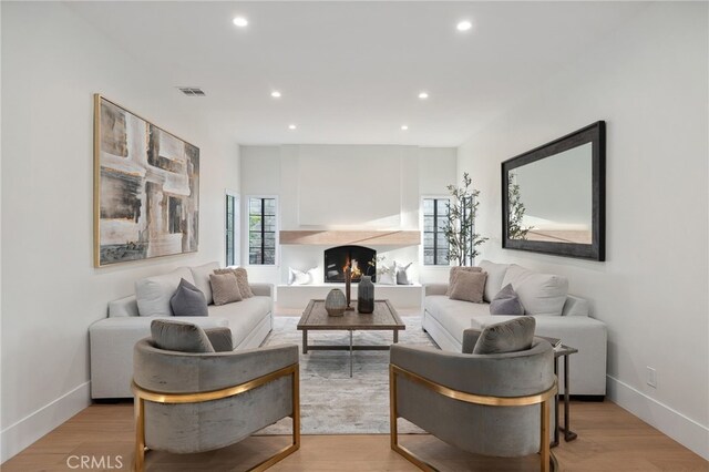 26065 Charing Cross Rd, Valencia, CA 91355 - living room with recessed lighting, a lit fireplace, light wood-type flooring, and baseboards