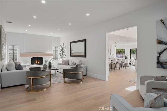 26065 Charing Cross Rd, Valencia, CA 91355 - living area featuring recessed lighting, light wood-type flooring, a lit fireplace, and baseboards