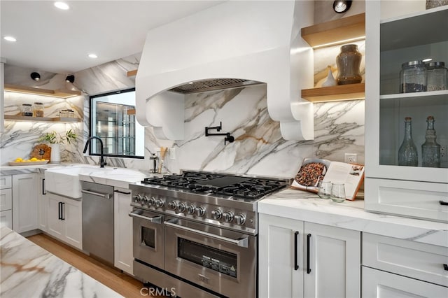 26065 Charing Cross Rd, Valencia, CA 91355 - kitchen with appliances with stainless steel finishes, open shelves, a sink, decorative backsplash, and light stone counters