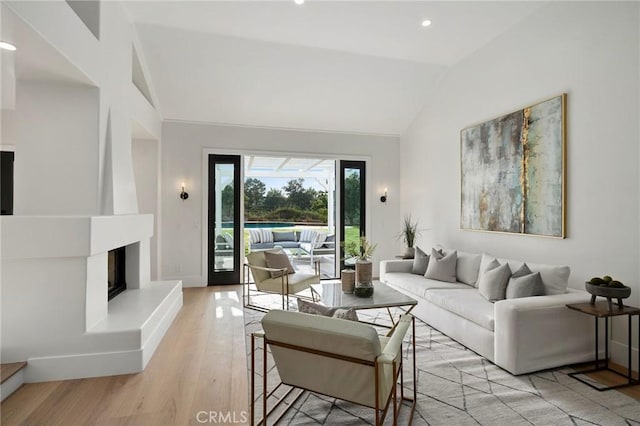 26065 Charing Cross Rd, Valencia, CA 91355 - living room featuring vaulted ceiling, light wood-type flooring, recessed lighting, a large fireplace, and baseboards