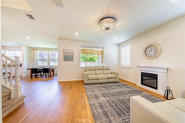 24207 Via Perla, Valencia, CA 91354 - living area with wood finished floors, stairs, a glass covered fireplace, baseboards, and recessed lighting